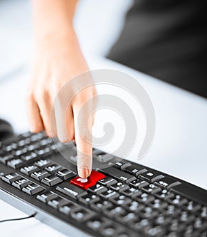 hand pressing red button with heart on keyboard