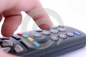 Hand pressing remote control button on white