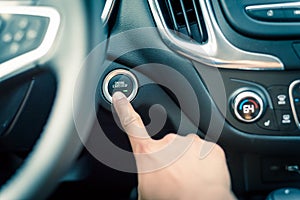 Hand pressing the start stop button on keyless car