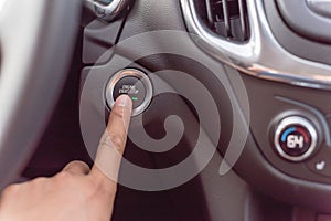 Hand pressing the start stop button on keyless car