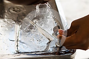 Hand pressing a water fountain button. quench your thirst