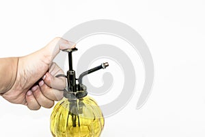 Hand pressuring yellow spray glass bottle isolate