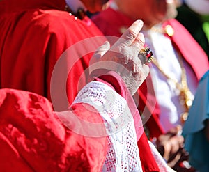 priest with large ring during the blessing of the faithful at the end of the religious event during the holidays