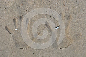 Hand prints with wedding bands on beach sand