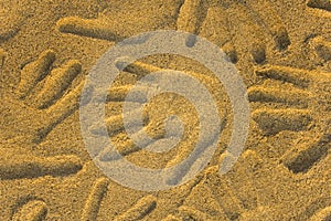 Hand prints in yellow sand close up