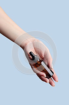 Hand, product and serum with a woman in studio on a gray background to promote an antiaging treatment. Skincare, beauty