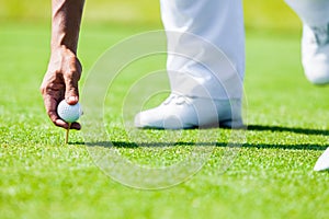 Hand of Professional Golf Player teach how to Teed Up Golf Ball