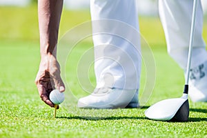 Hand of Professional Golf Player teach how to Teed Up Golf Ball