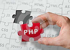 Hand of programmer holds puzzle with PHP programming language