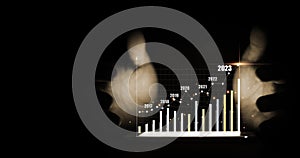 Hand protecting smartphone with virtual increasing technical graph and up arrow for trader analysis business stock market chart