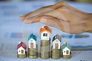 Hand protection, house model on top of stack of money as growth of mortgage credit, Concept of property management. Invesment and