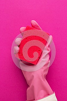 Hand in protective glove holding red sponge