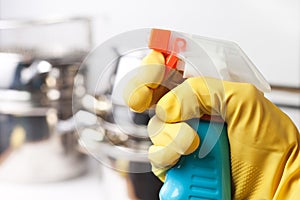 Hand in protective glove holding spray