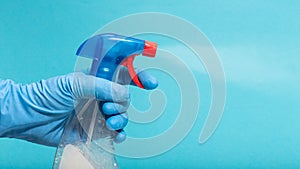 Hand in protective glove spraying disinfectant