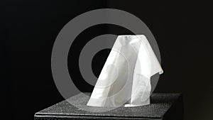 hand pull out a piece of tissue from tissue paper box