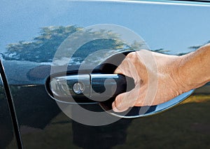 A hand pulling car door handle