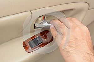 Hand pulling car interior door handle, opening the door