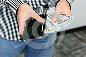 Hand pulling 100 dollars banknotes