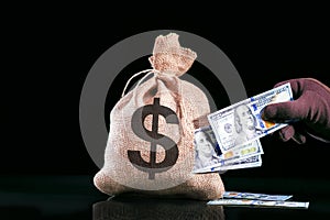 Hand pulls money, dollars out of the bag.