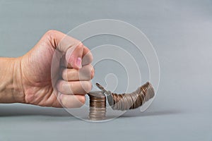 Hand punch the increasing columns of coins on white background,