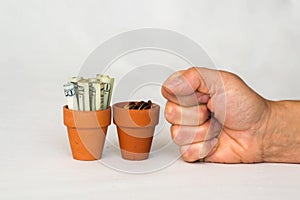 Hand punching money in terracotta pots