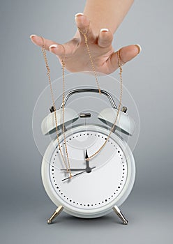 Hand puppeteer manipulating clock, time management concept