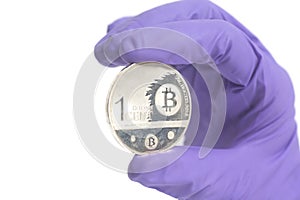 Hand in Purple Glove holds silver bitcoin Crypto Currency.Mining concept.