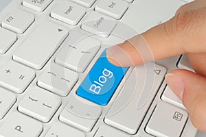 Hand pushing blue blog button