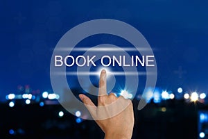 Hand pushing book online button on touch screen