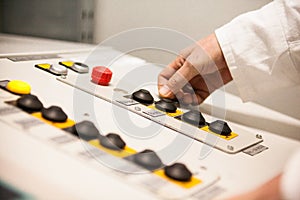 Hand pushing the button on the control panel