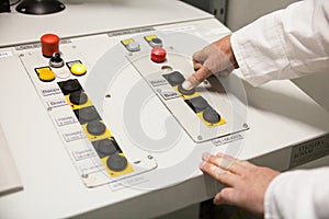 Hand pushing the button on the control panel