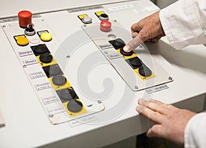Hand pushing the button on the control panel