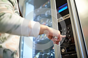 Hand pushing button on vending machine keyboard