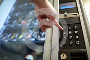 Hand pushing button on vending machine keyboard photo