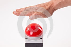 Hand pushing a red buzzer