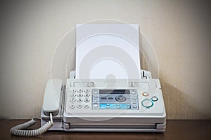 A hand pushing start button old fax