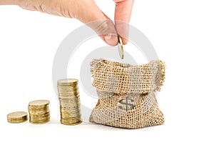 Hand put coin in bag with money isolated on white, investment or growth concept