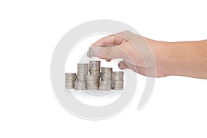 Hand put coins to stack of coins isolated on white