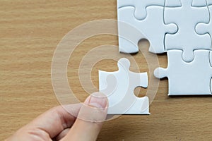 Hand put the last piece of jigsaw puzzle to complete the mission, Business solutions, success and strategy concept