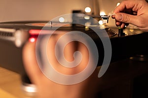 hand put tonearm on vinyl record starting turntable close up.