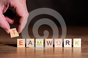 Wooden blocks with letters in a row, word Teamwork