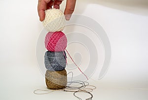 Hand puts a ball of thread