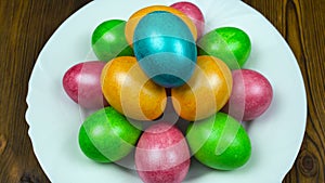 Hand puts on a plate the Easter decorated and painted colored egg during a Resurrection Sunday or Pascha