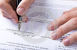Hand puts the signature in the contract