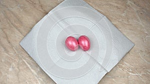 Hand puts on a table the Easter decorated and painted colored egg during a Resurrection Sunday or Pascha