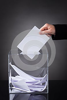 Hand putting ballot in box