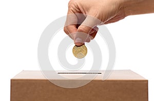 hand putting coin into charity donation box