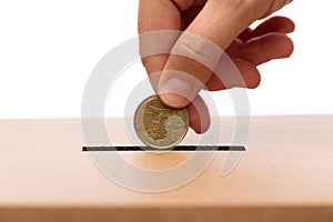 hand putting coin into charity donation box