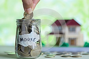 Hand putting coin in glass jar