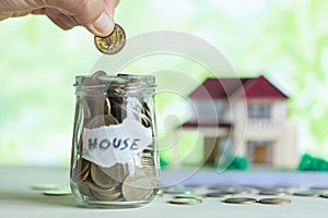 Hand putting coin in glass jar